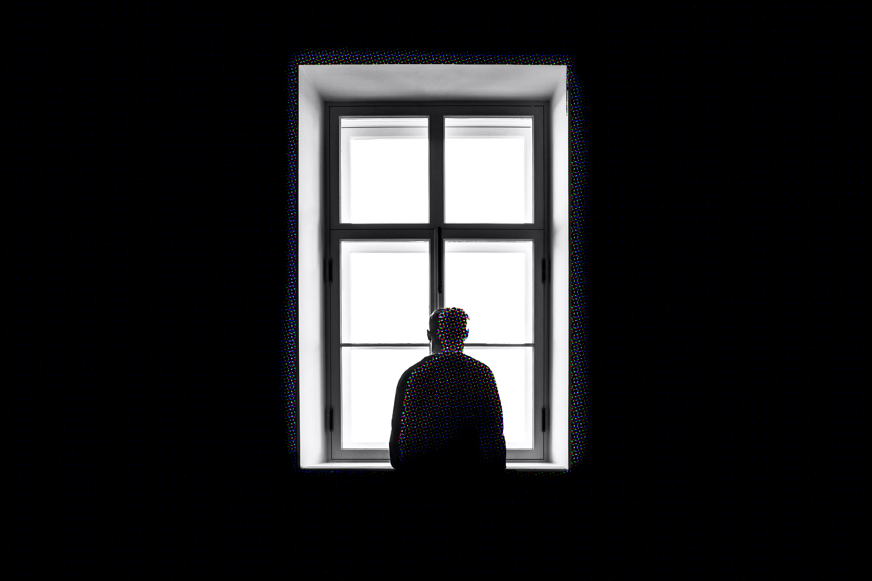Edited picture of a man staring out of window.